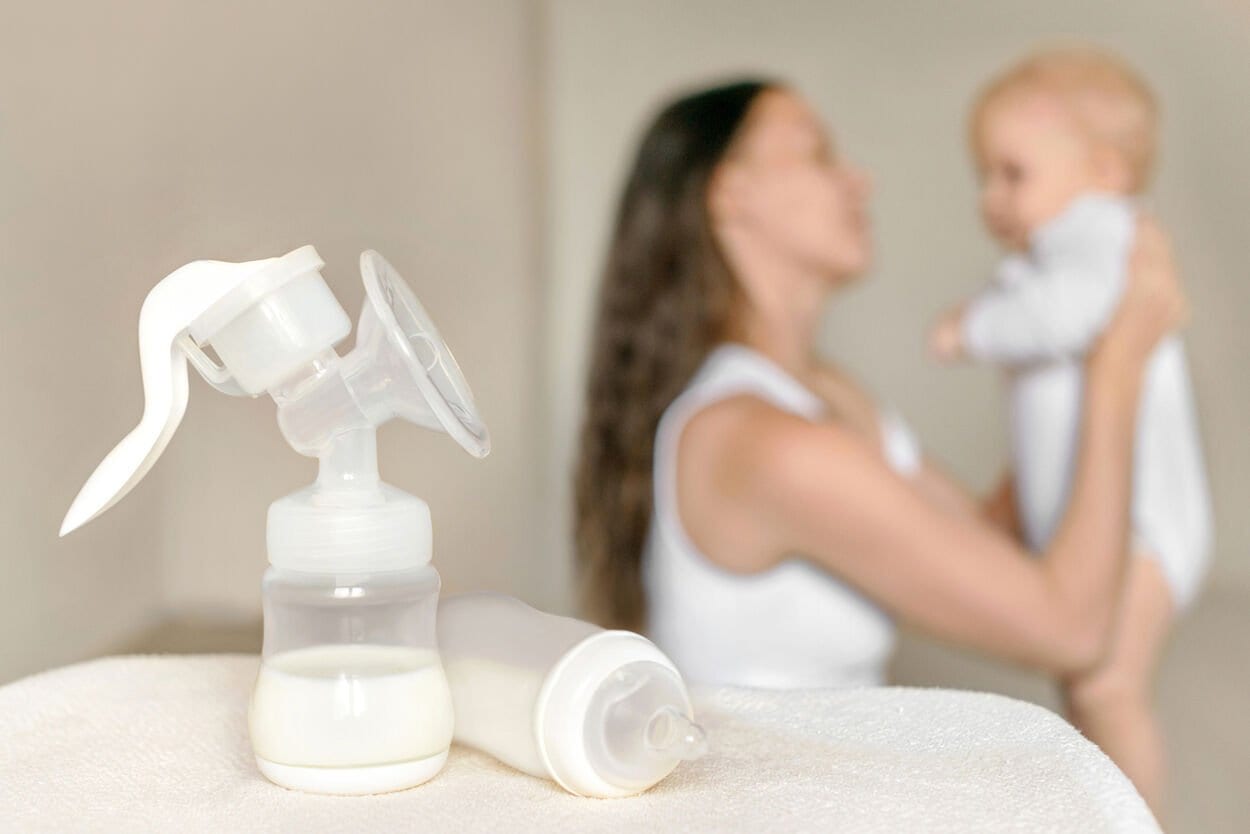 Moeder die haar baby in haar handen heeft na het kolven van haar moedermelk.