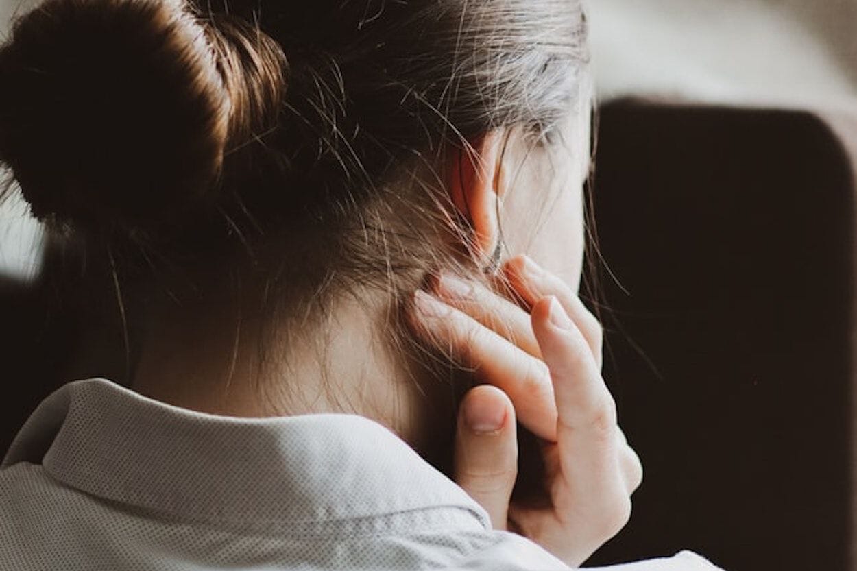 vrouw die krabt aan haar nek omdat ze jeuk heeft