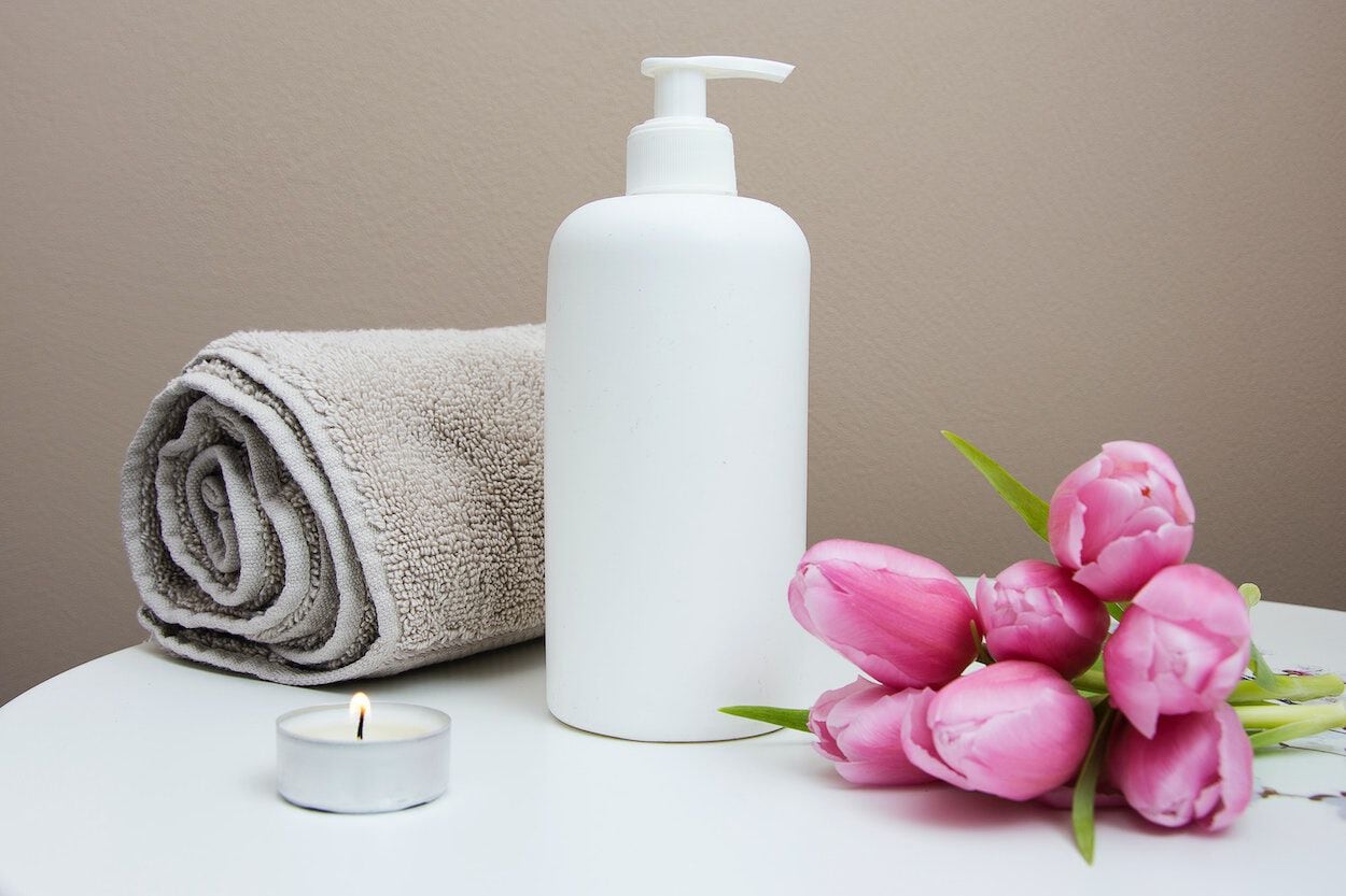 handdoek, pompje en bloemen voor een massage