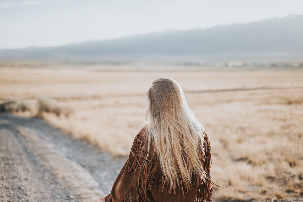 blonde vrouw die naar een weg kijkt