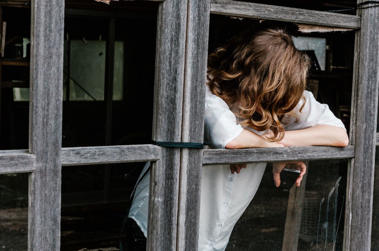 vrouw kijkt uit raam