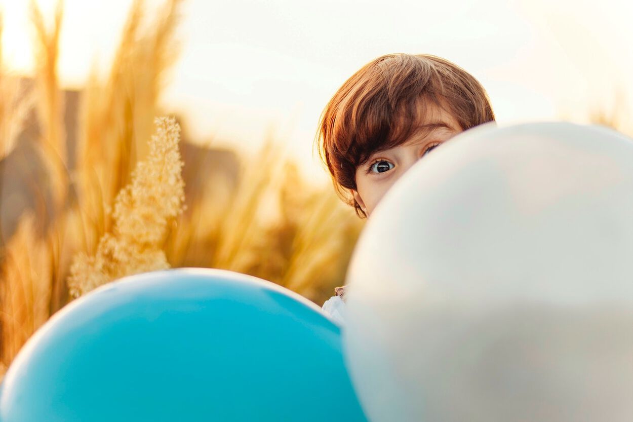 Jongen achter ballonnen