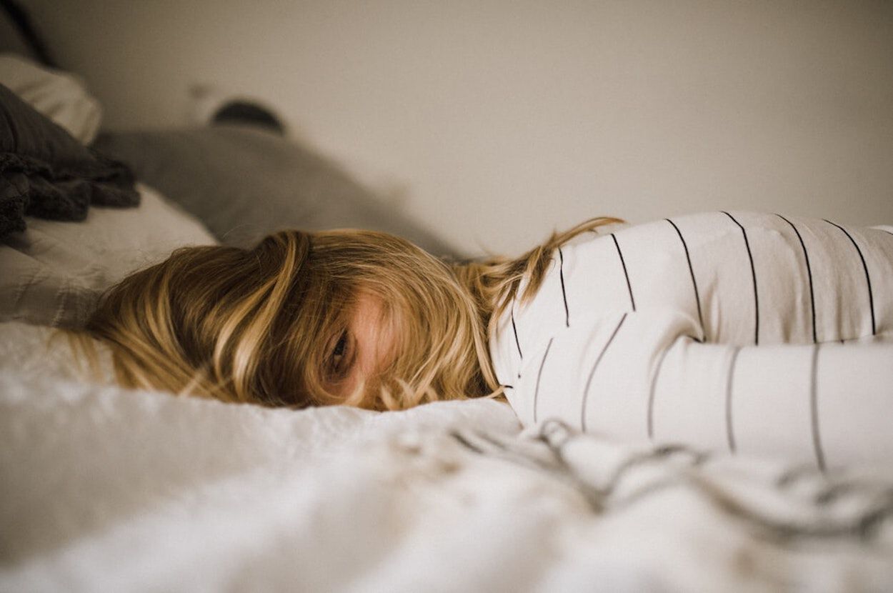 meisje ligt met haar hoofd op haar bed