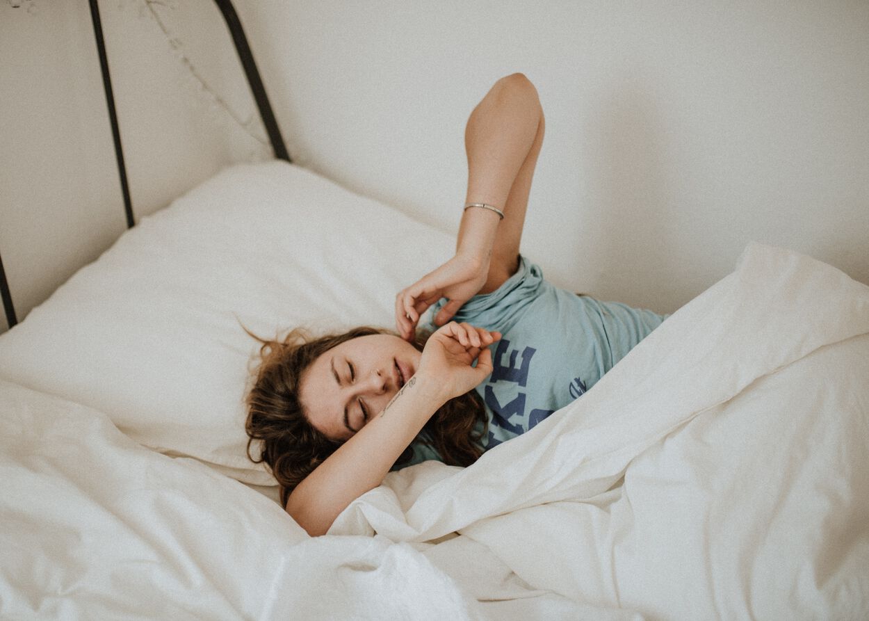 vrouw ligt vermoeid in bed