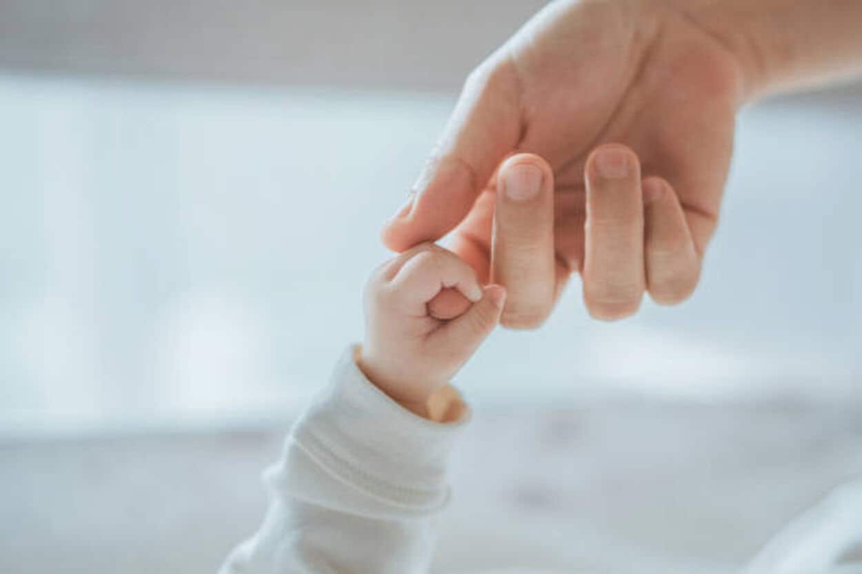 Handje van een baby die verkouden is