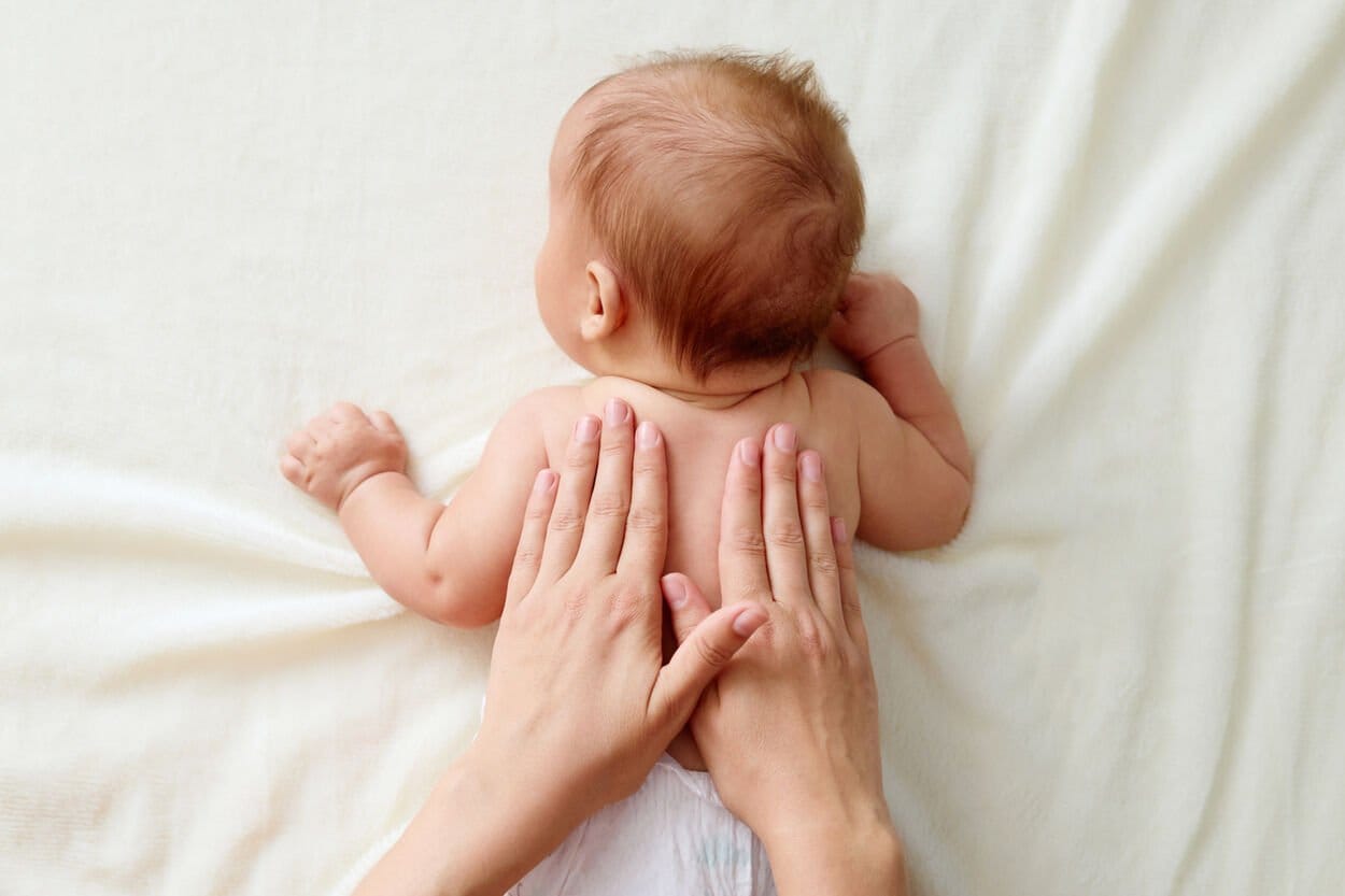 Moeder die haar baby een rustgevende babymassage geeft