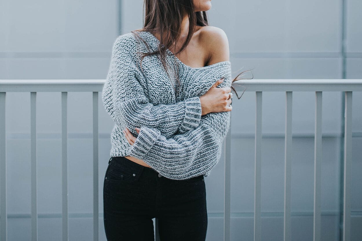 vrouw in trui met blote schouder