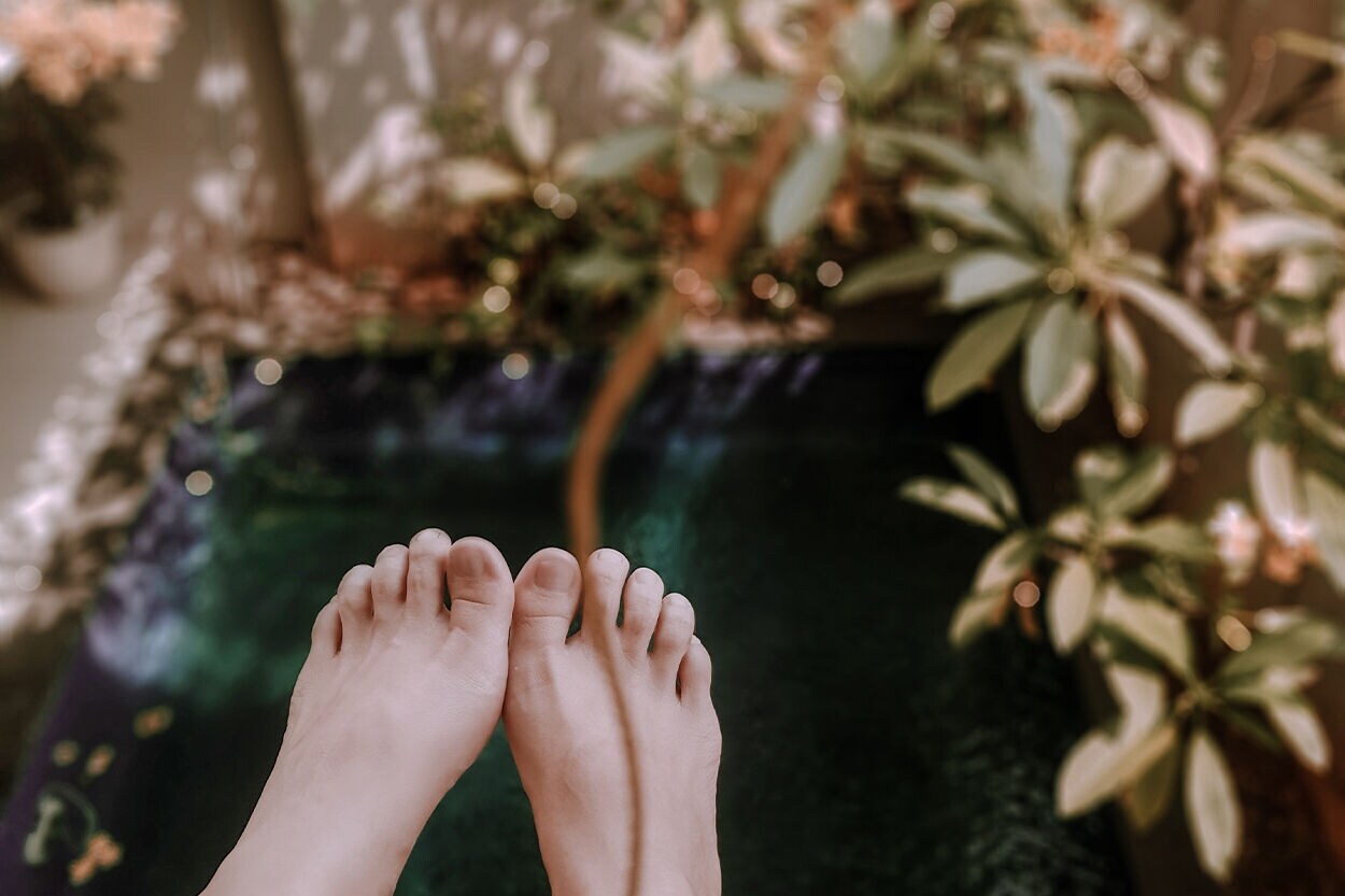 voeten met gelakte teennagels en slippers