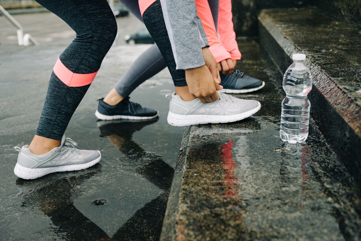 vrouwen die veters van sportschoenen vastmaken op trap
