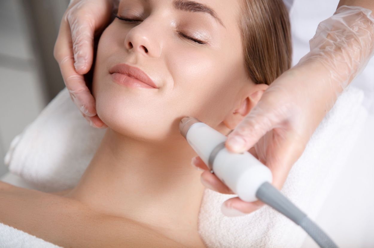 Een glimlachende vrouw ondergaat een acne behandeling
