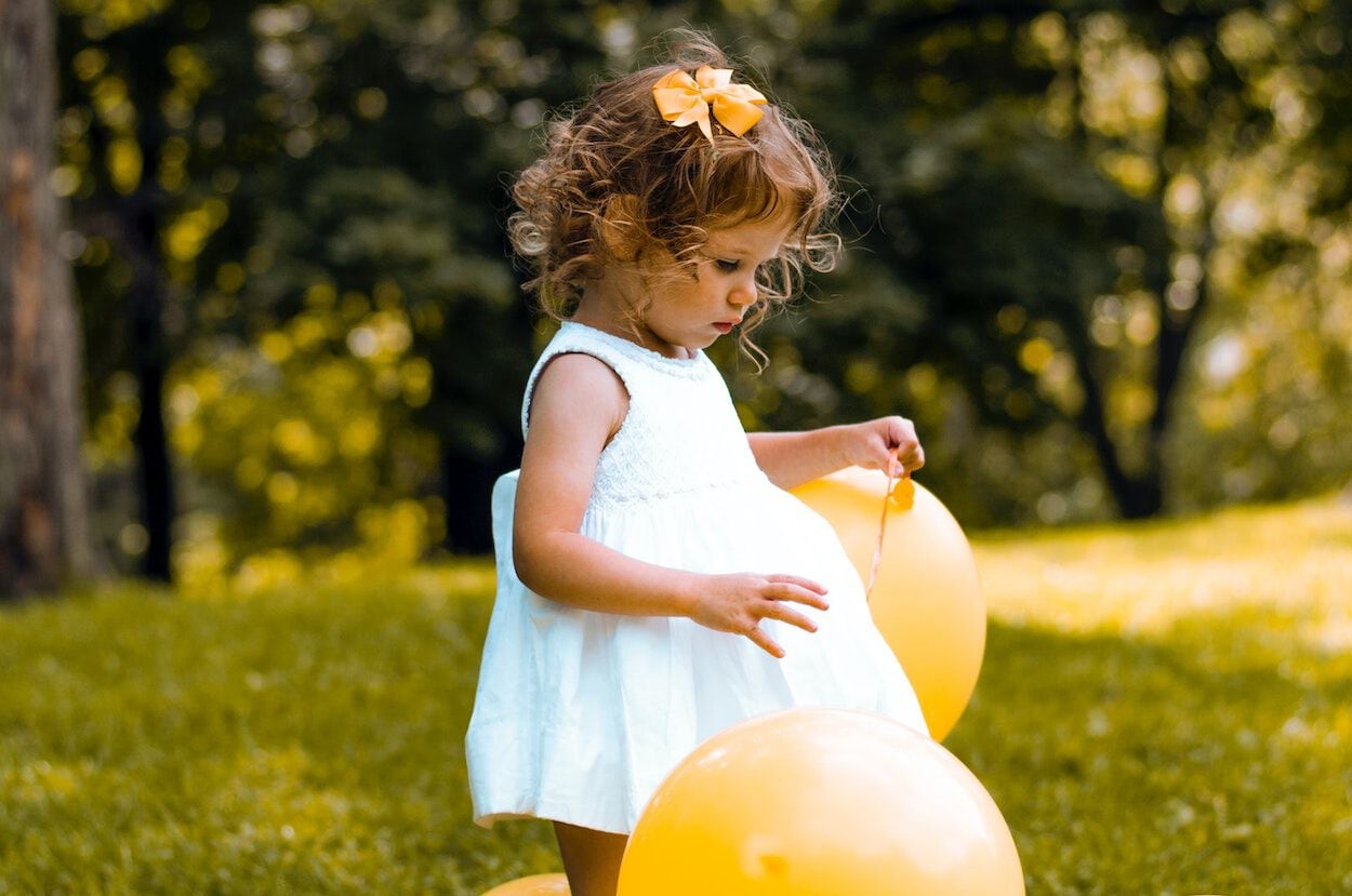 meisje in grasveld met ballon