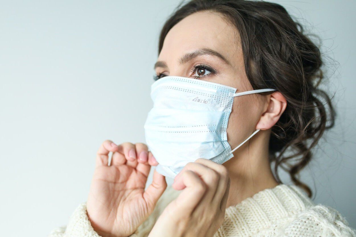 Vrouw die een mondmasker op heeft. Ze heeft net een Corona-antistoffentest uitgevoerd.