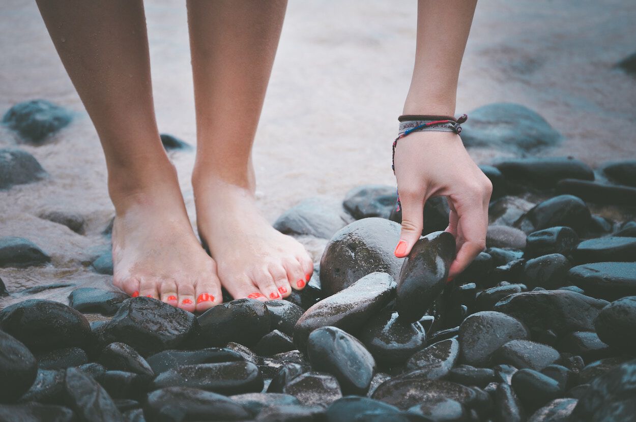 vrouw met gelakte nagels op het strand