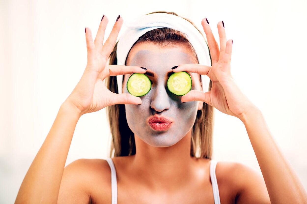 vrouw met gezichtsmasker en komkommer
