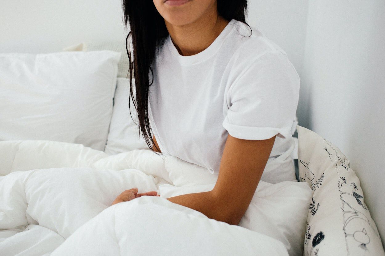 vrouw met wit t-shirt zit in bed