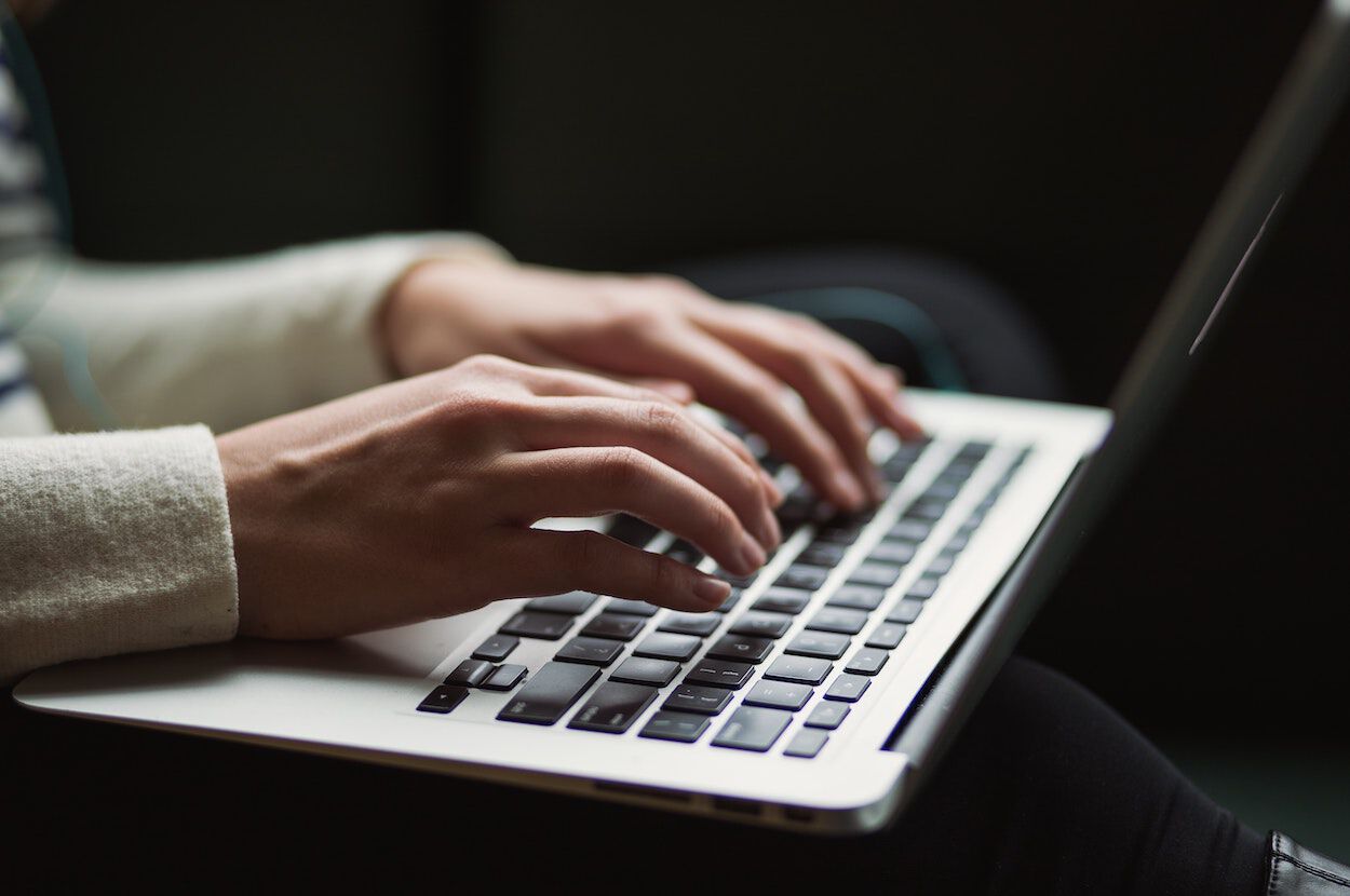 handen die typen op een laptop