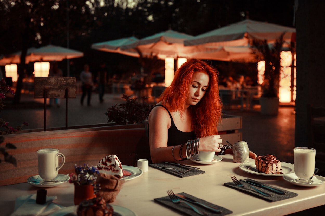vrouw met rood haar zit in restaurant