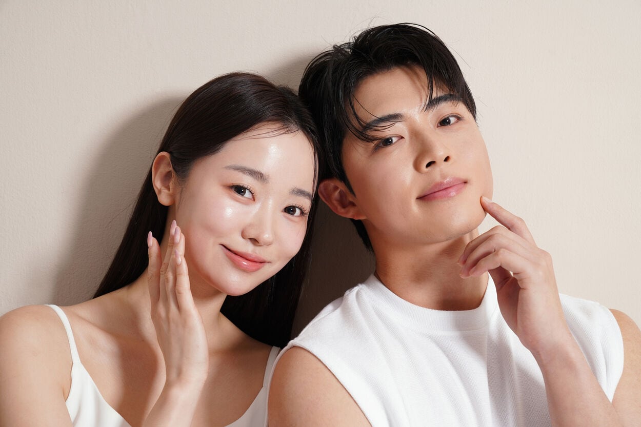 Koreaanse man en vrouw die Korean skincare aanbrengen op hun gezicht