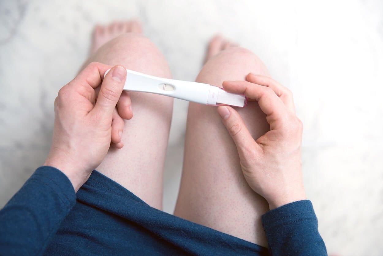 vrouw met zwangerschapstest in de handen