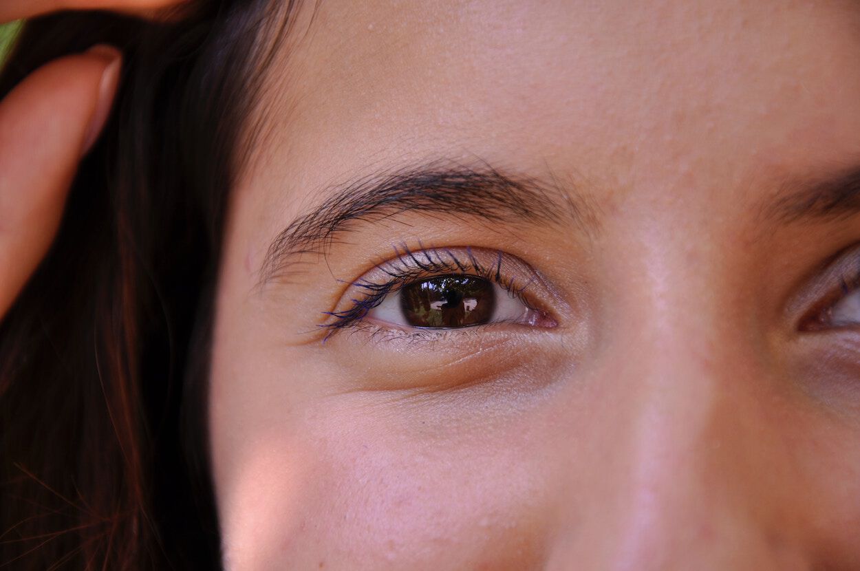 close up van oog van een lachende vrouw met donkere wimpers