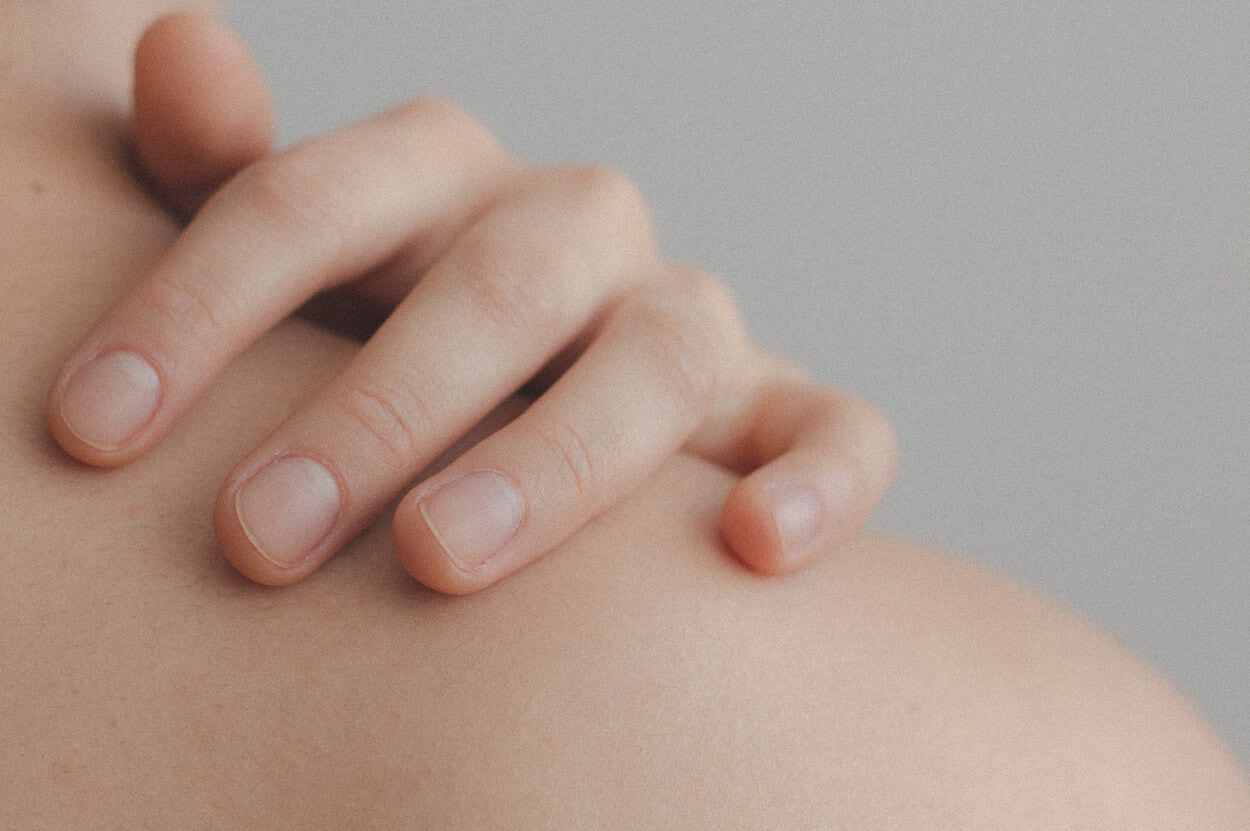 vrouw met blote rug kijkend naar de zee