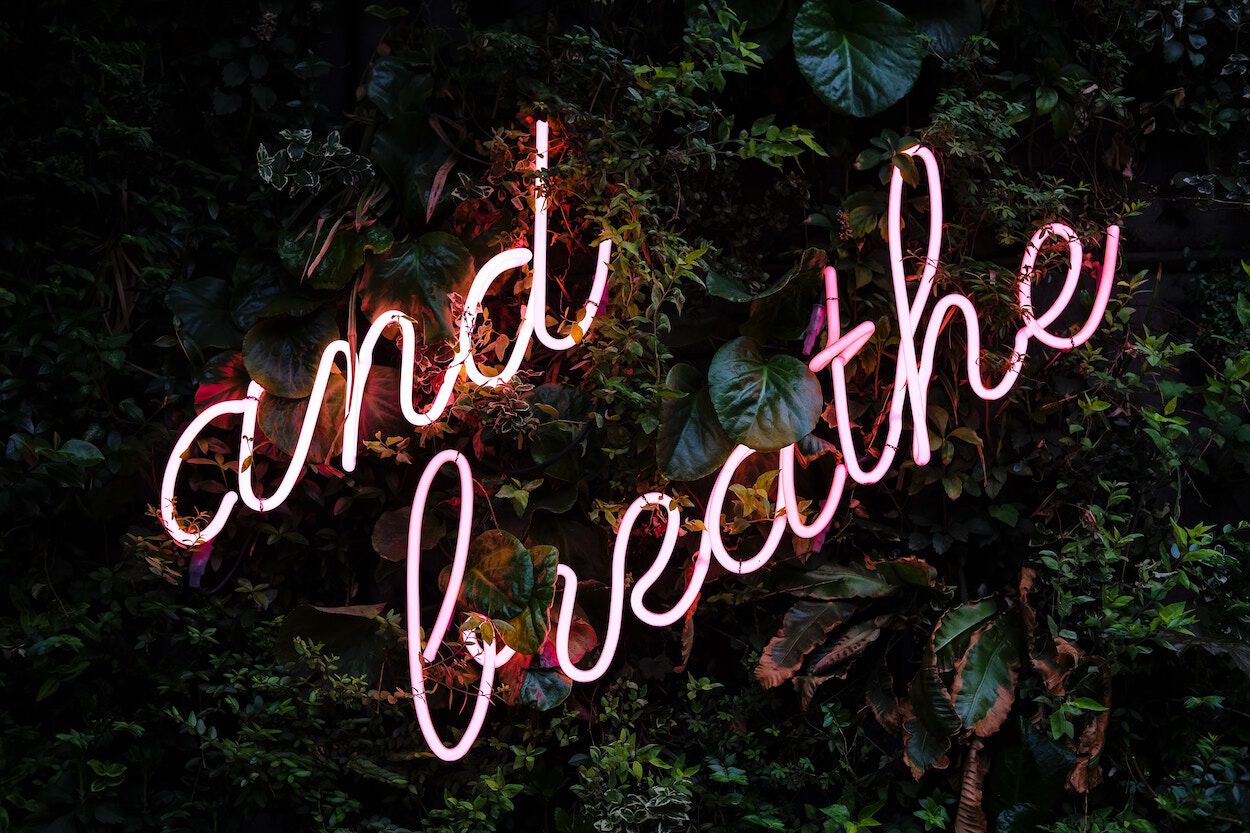 roze neon tekst &#039;and breath&#039;