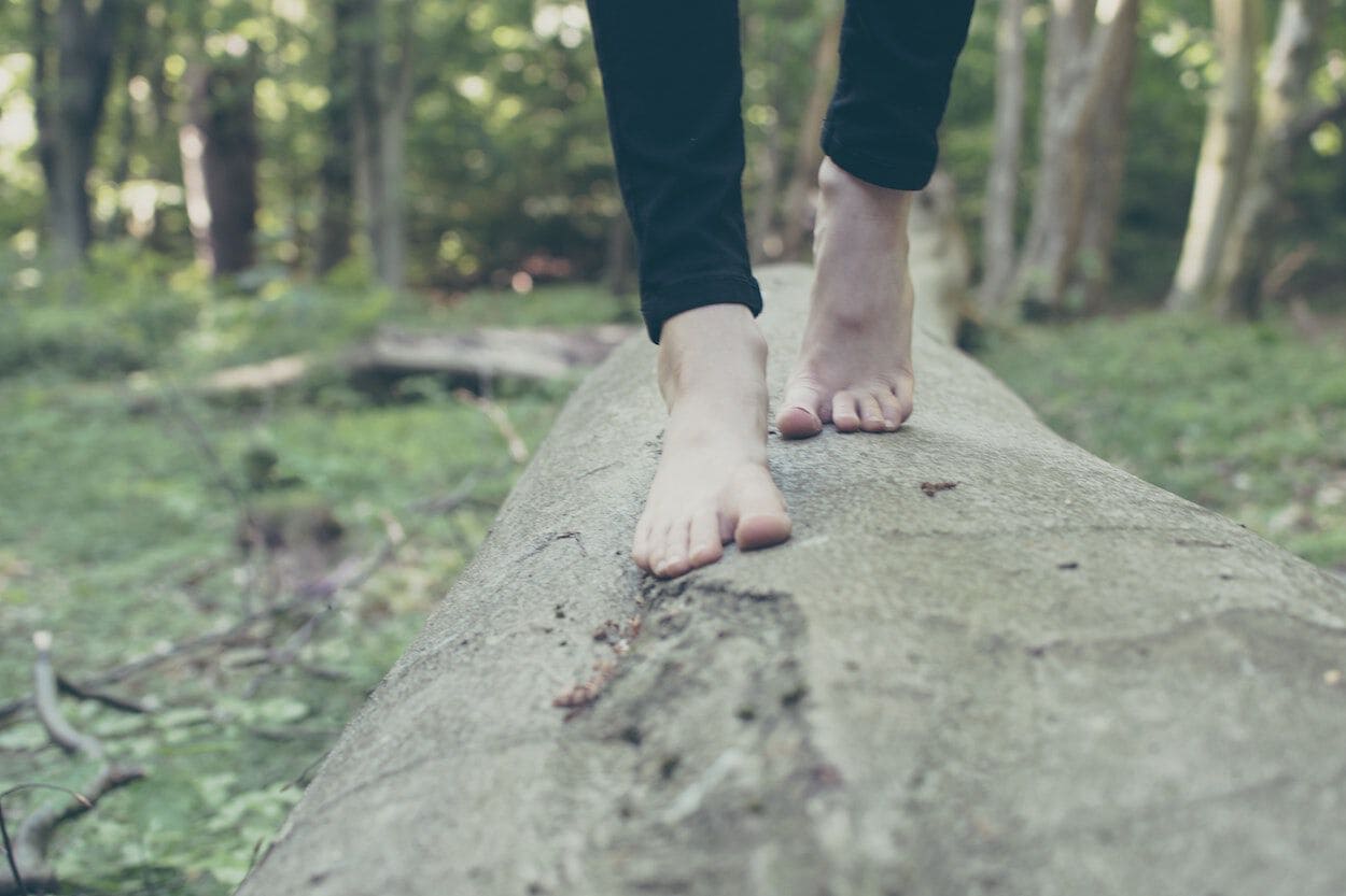 Blote voeten op boomstam hout