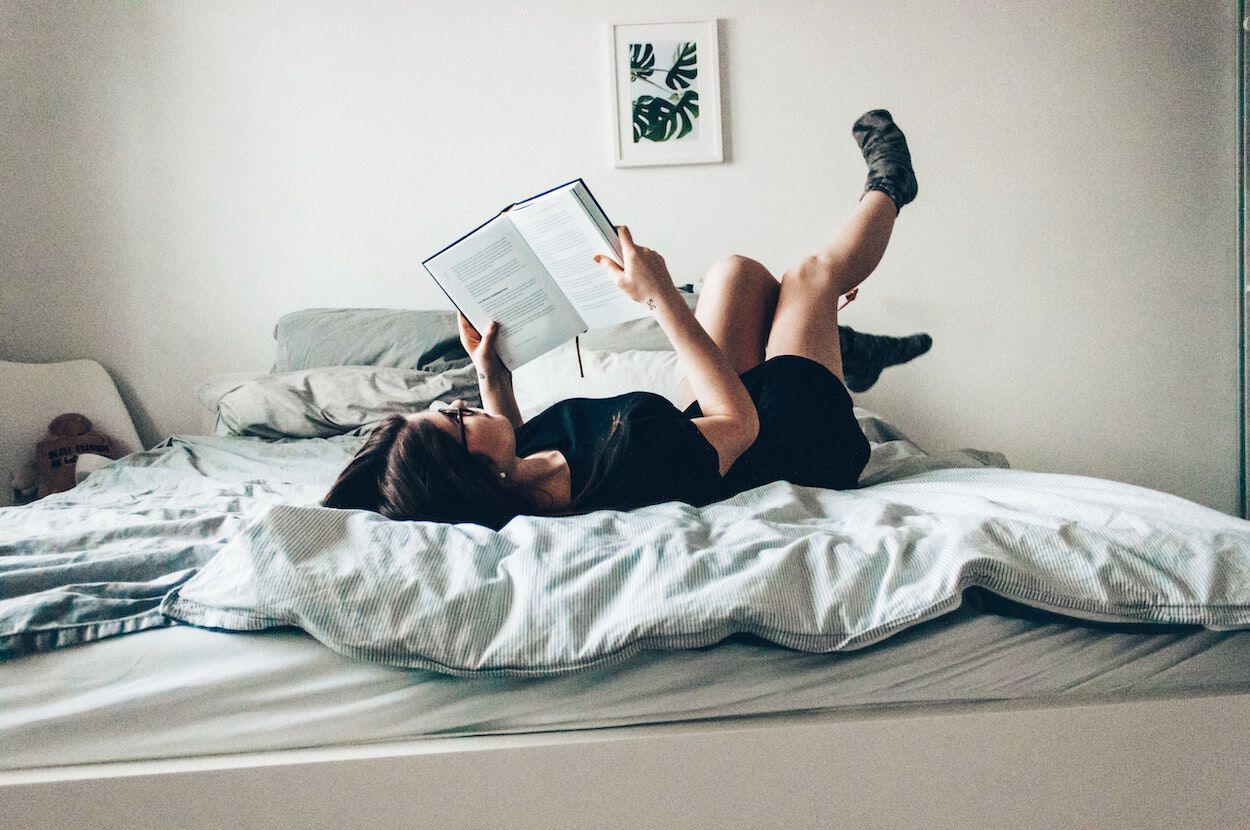 vrouw leest boek op bed