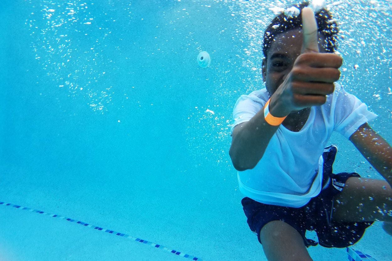 kind onder water in een zwembad