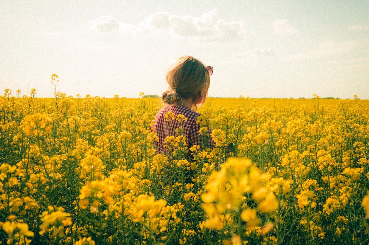 vrouw in een geel bloemenveld