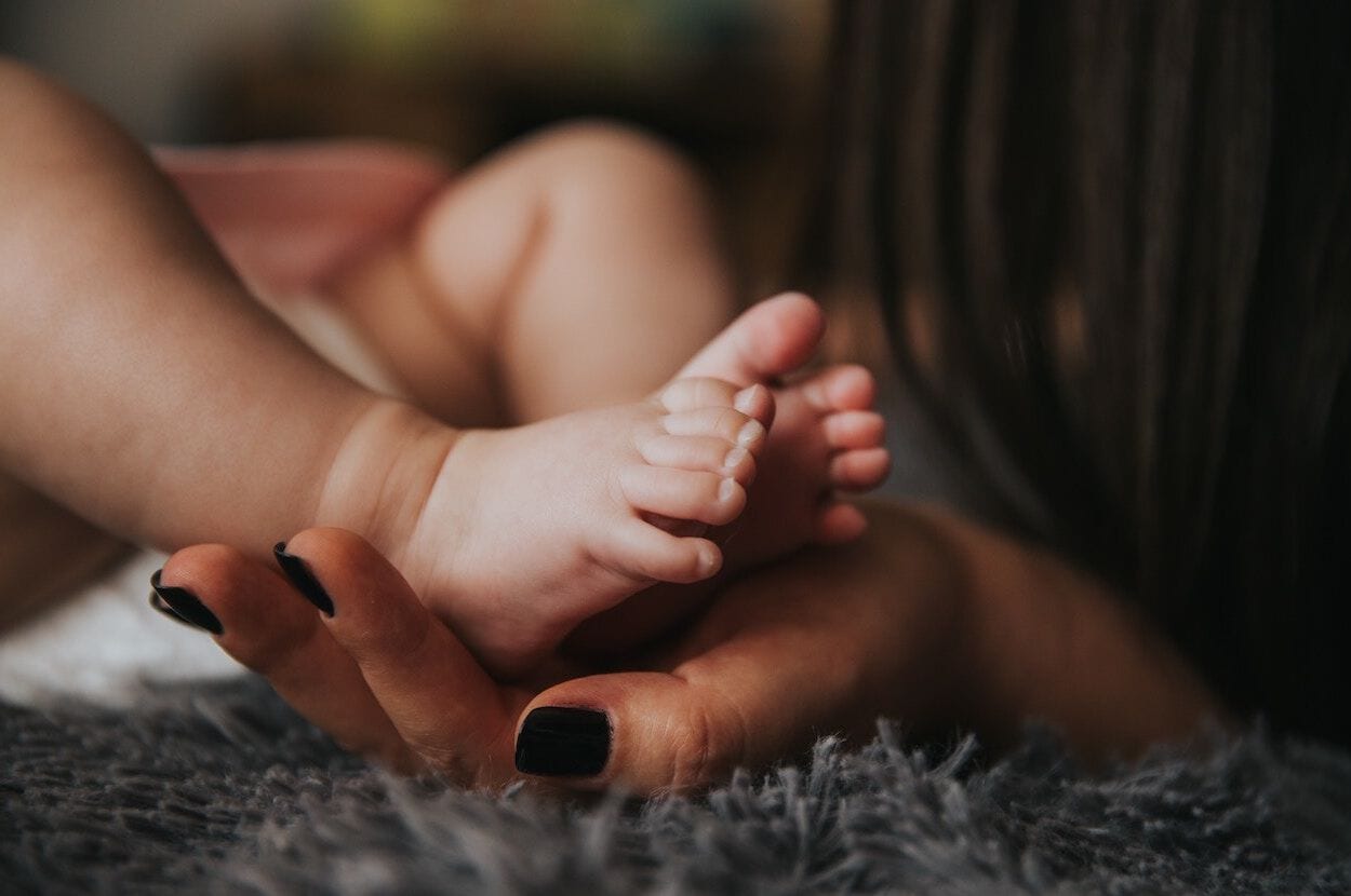 babyvoetjes in de hand van de moeder