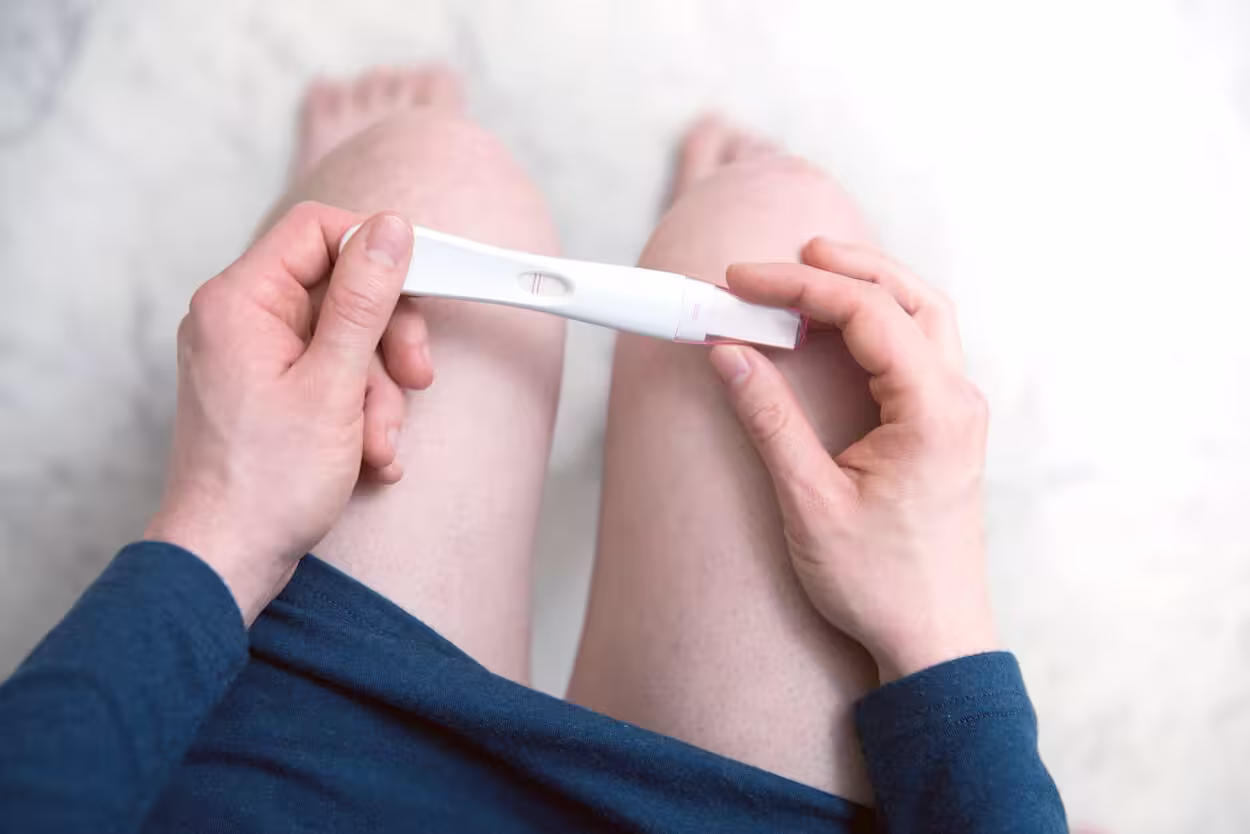 Vrouw die net een zwangerschapstest heeft gedaan en een positieve resultaat ziet