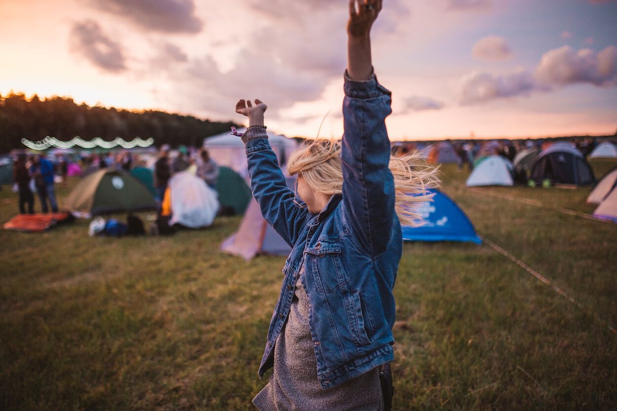 vrouwen lachend op festival blond haar en tentjes