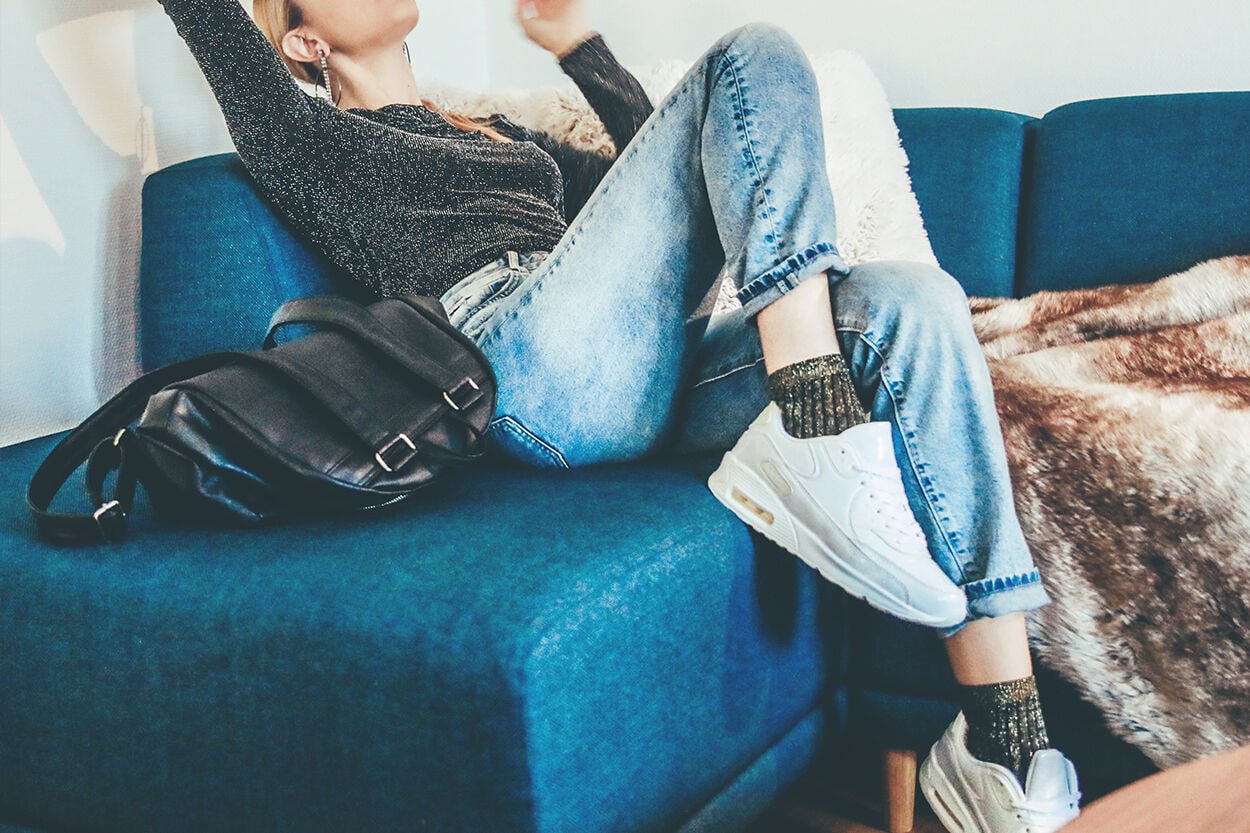 vrouw op de bank die mogelijk vermoeide benen en voeten heeft