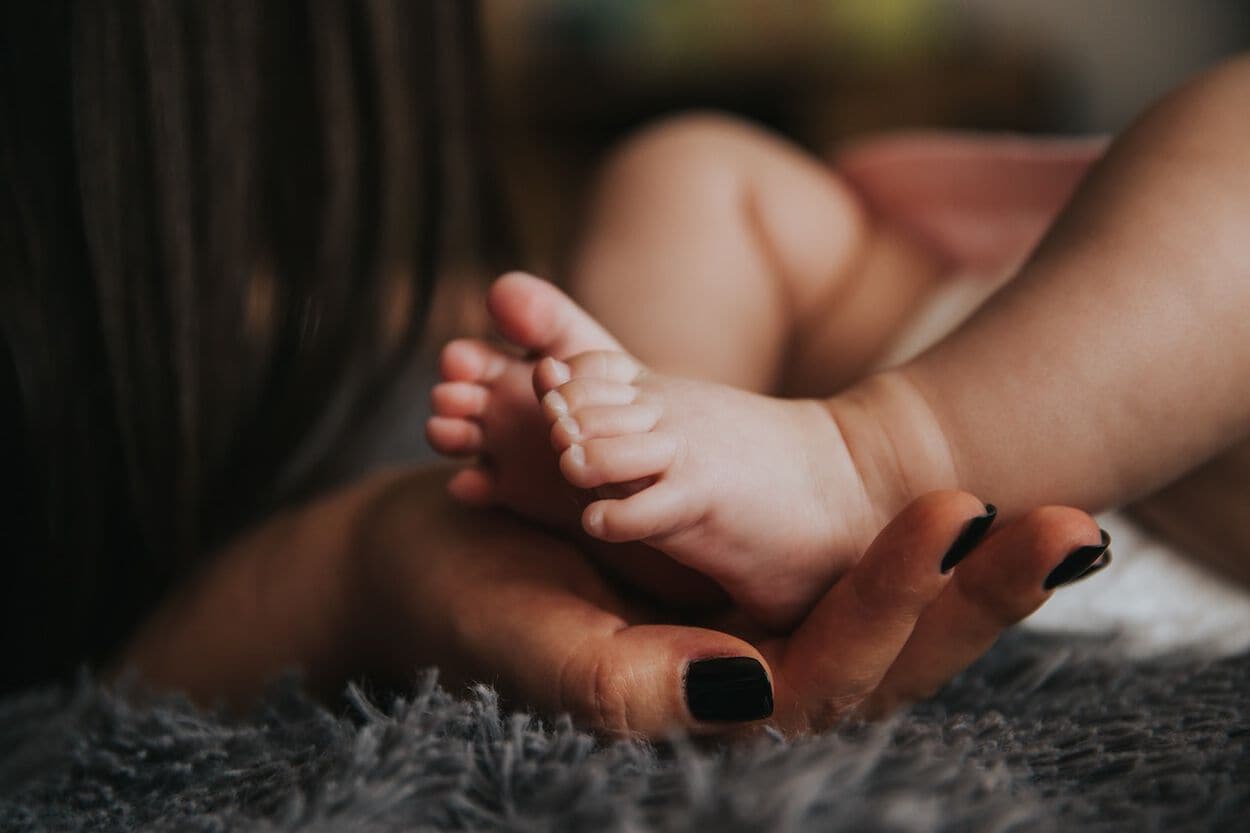 volwassen hand met babyvoetjes erin