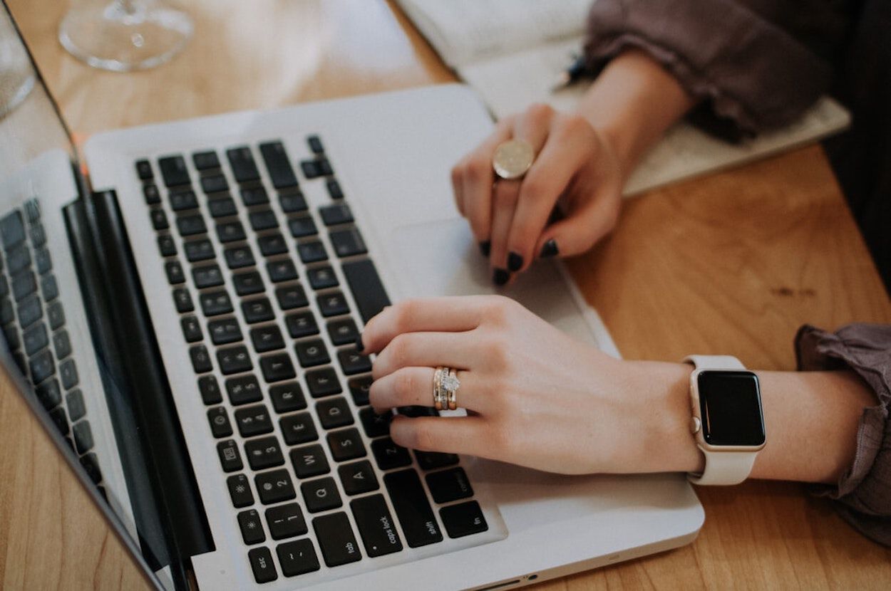 meisje typt op toetsenbord van laptop
