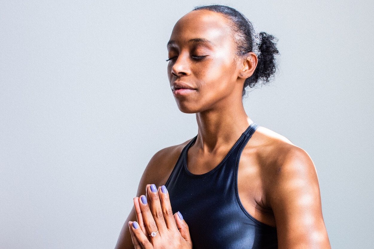 Vrouw in sportkleding: ze is aan het mediteren.