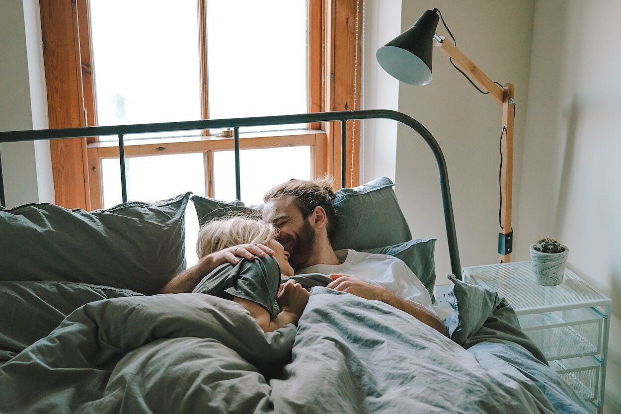 man en een vrouw liggen in een bed