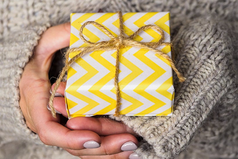twee handen met een klein cadeautje erin
